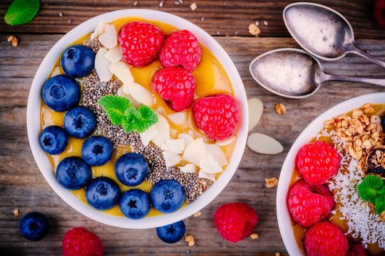 Mango smoothie bowl with raspberries, blueberries, chia seeds and almonds