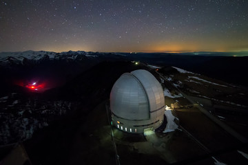 Fototapeta na wymiar Night view from above to the large dome of the telescope of the special astrophysical observatory in the Arkhyz mountains.