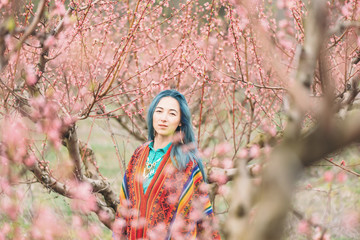 Beautiful girl walking in flowering garden.