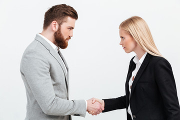 Serious colleagues shaking hands.