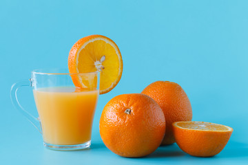 glass of citrus juice with vibrant orange on a light background texture with copy space.