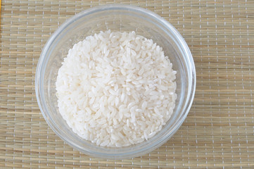 Bowl of rice on a bamboo placemat, from above