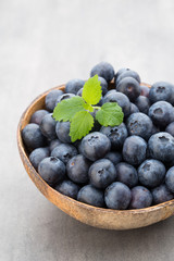 Fresh blueberries natural coconut in a bowl on a gray background.