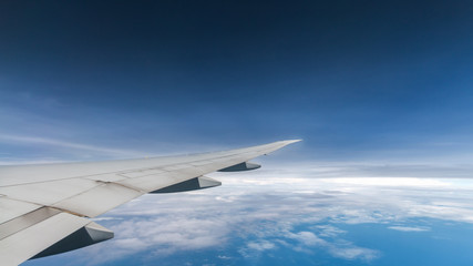 Fototapeta na wymiar cloud blue sky and plane wing view through