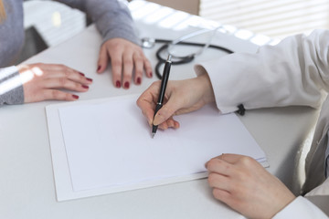 Doctor and patient are discussing about diagnosis, just hands at the table.