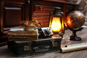 composition on a wooden floor vintage globe with old leather suitcase