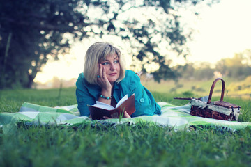 woman lay and read book sun