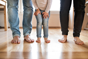 Beautiful young family. Bare feet of mother, father and daughter