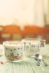 Morning granola with yogurt and berries on wooden kitchen table. Concept healthy breakfast. Toned.
