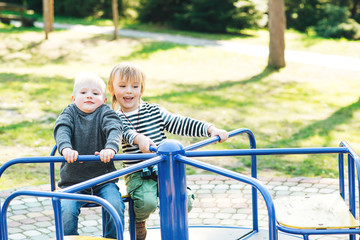 Fototapeta na wymiar Two happy boys playing on playground in a park.