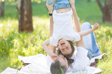 Happy baby girl toddler having fun with her father outdoors in the park