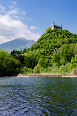 Castle of Montaldo Dora, in Canavese (Piedmont, Italy) with lake Pistono and Alps on the background