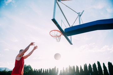Young man jumping and making a fantastic slam dunk playing stree © FS-Stock