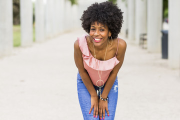 portrait of  a Happy young beautiful afro american woman smiling. White columns background. Spring or summer season. Casual