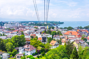 View of a pfanderbahn cable car with the Austrian city Bregenz behind it.