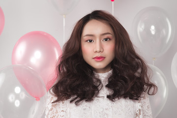 Asian pretty fashionable woman in white dress with pastel balloons