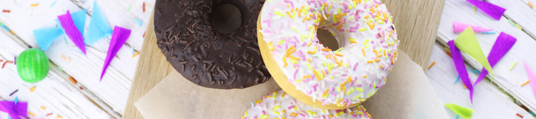 Horizontal bakground of donuts on a wooden