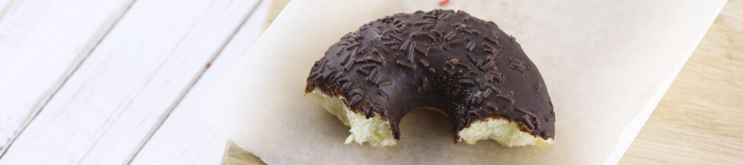 Horizontal bakground of chocolate donuts on a table