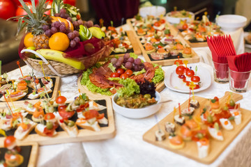 Fototapeta na wymiar Beautifully decorated catering banquet table with different food snacks and appetizers
