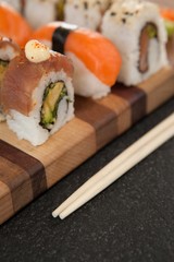 Assorted sushi set served with chopsticks on wooden board