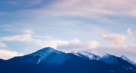 Naklejka na ściany i meble Photo depicting a beautiful moody frosty landscape European alpine mountains with snow peaks on a blue sky background.
