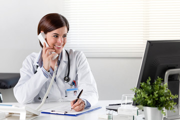 Female doctor at desk with telephone