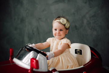 two babies wedding - girl dressed as bride playing with toy car