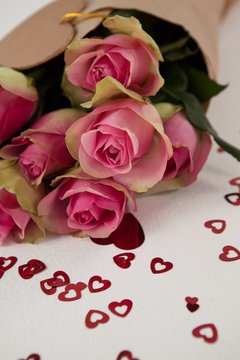 Bunch of pink roses surrounded by heart-shaped decoration