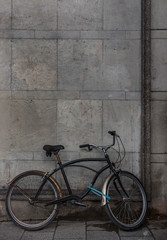 Fototapeta na wymiar old rusty vintage style bicycle on dark grey concrete wall background