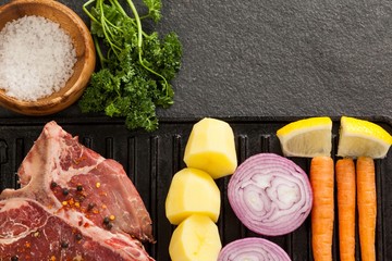 Sirloin chop and ingredients on black grill