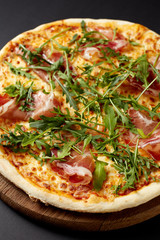 Hot pizza Prosciutto on a rustic wooden table.
