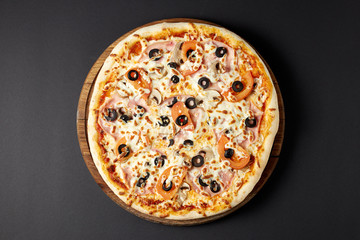 Hot pizza Regina on a rustic wooden table.