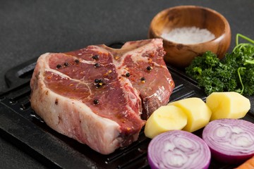 Sirloin chop and ingredients on black grill
