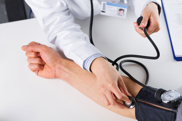 Female Doctor Checking Blood Pressure Of Patient - 150164555
