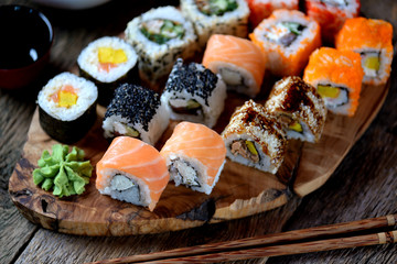 Homemade sushi with salmon, tobiko caviar, omelet, cucumber, sesame and soft cheese. Rustic style.