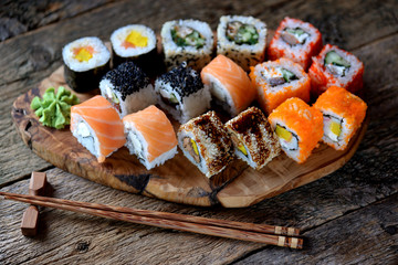 Homemade sushi with salmon, tobiko caviar, omelet, cucumber, sesame and soft cheese. Rustic style.