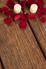 Wax candles surrounded with rose petals © wavebreak3