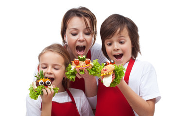 Fototapeta na wymiar Kids and woman taking a bite of funny creatures sandwiches