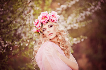 A young girl in floral wreath in nature