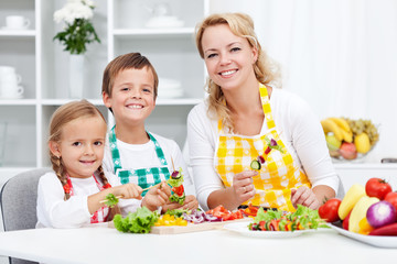 Young kids with their mother in the kitchen
