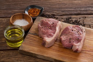 Sirloin chops on wooden board with ingredients