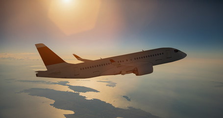 Naklejka na ściany i meble Airplane in flight over sea during sunset