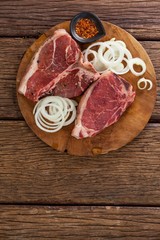 Blade chop, onions and spices on wooden round tray