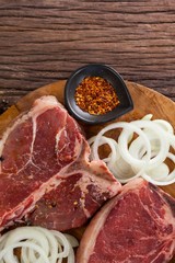 Blade chop, onions and spices on wooden round tray