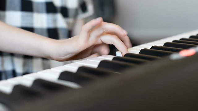 Little girl learning to play the piano.