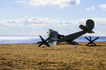 Shot down a plane from the times of World War II on the beach in the sand near the sea