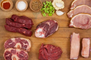 Varieties of meat with spices on wooden board