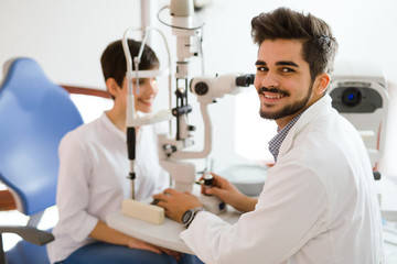 optometrist checking patient eyesight and vision correction - obrazy, fototapety, plakaty