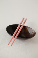 Pair of chopsticks over a bowl