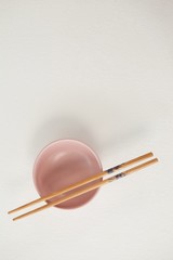 Pair of chopsticks over a bowl